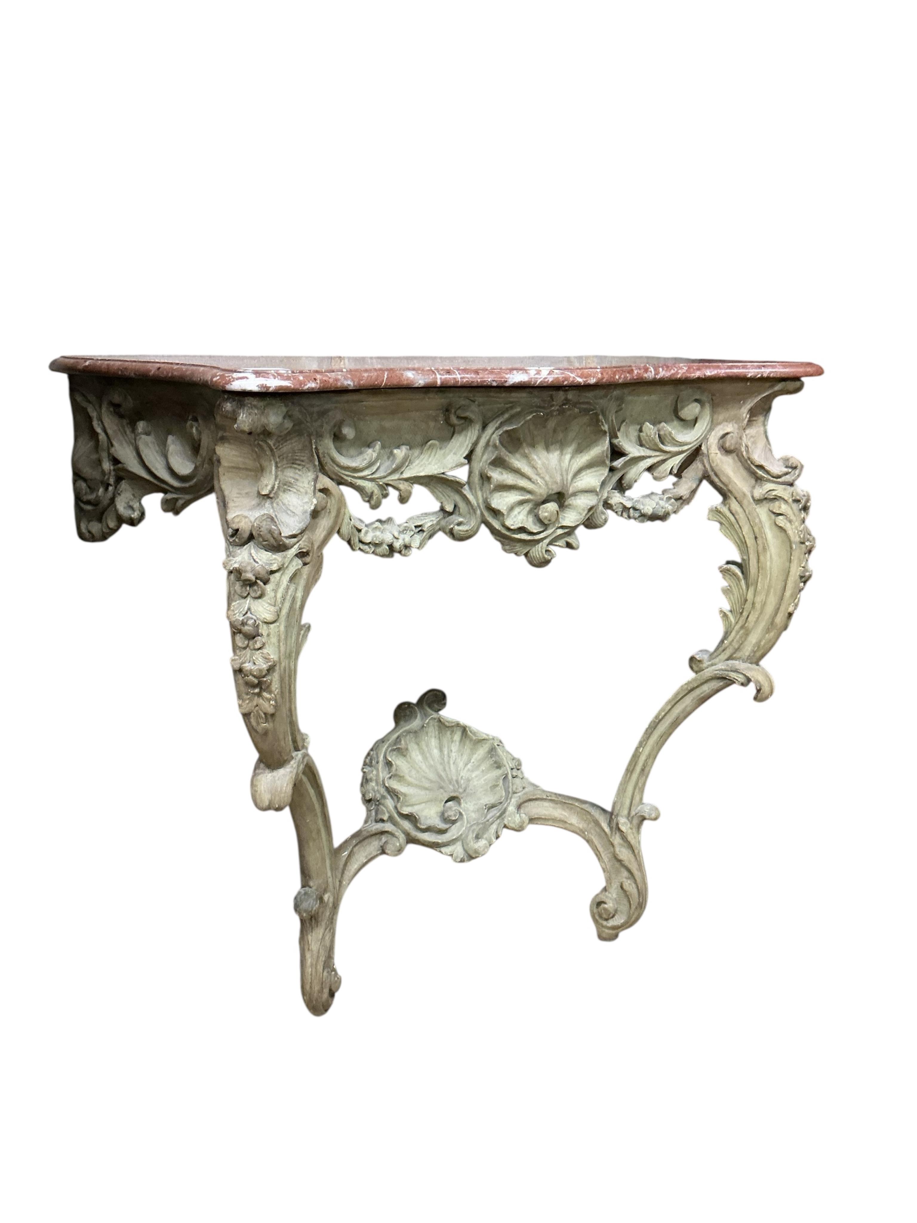 A Louis XV style console table the rouge marble serpentine top raised on a foliate, shell and floral swagged base with two cabriole style supports, width 100cm, depth 45cm, height 90cm